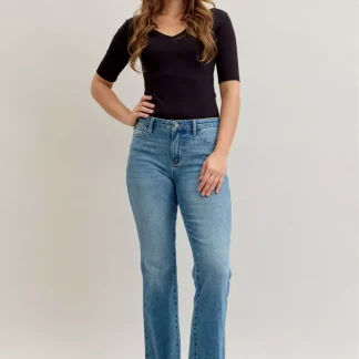 Calça jeans Judy Blue Plus Size, cintura média, corte bootcut slim, controle de barriga e barra com ajuste.