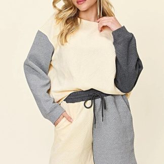 Conjunto de shorts de luxo de duas peças com bolsos e blusa de ombros caídos.