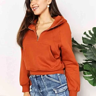Moletom com capuz e zíper frontal até a metade, mangas raglan longas e modelagem cropped.